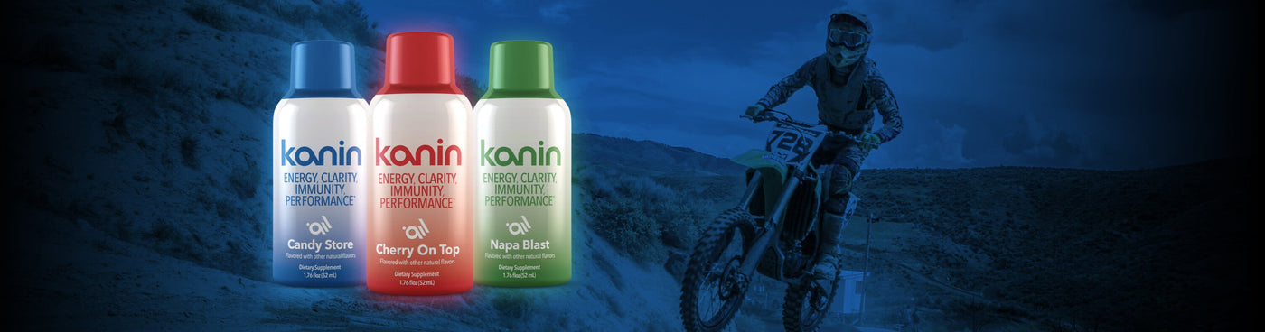 Three bottles of kanin energy drink products with a person on a motorcycle bike in the background