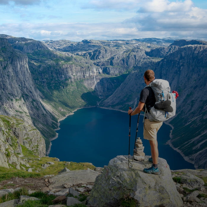 man hiking mountain, overlooking lake after taking Kanin energy drink for sustained energy and endurance
